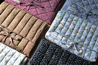 Collection of quilted fabric samples in various colors and patterns.